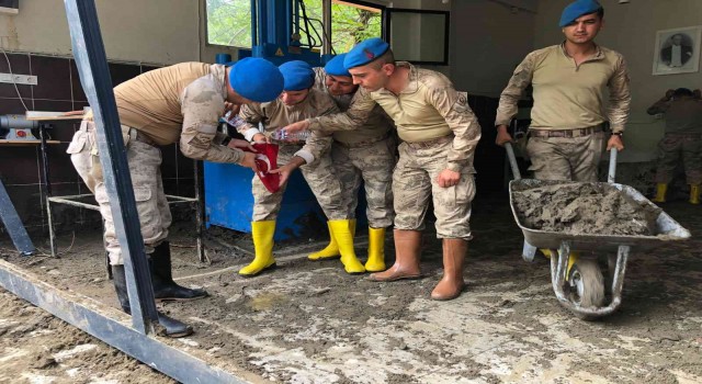 Komandolar çamurun altında buldukları Türk bayrağı ile Atatürk posterini yıkayıp öperek yeniden astı