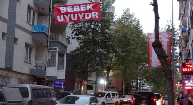 Araç gürültüsünden uyuyamayan bebeği için caddeye Bebek uyuyor afişi astı