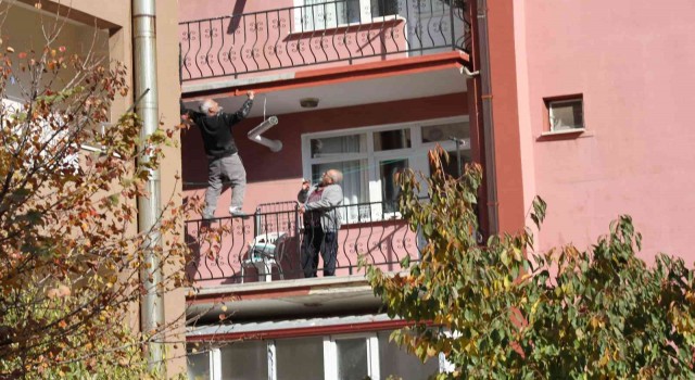 Çatıda yatarak sıva yapan usta bu kez de balkon demirine çıkıp boya yaptı