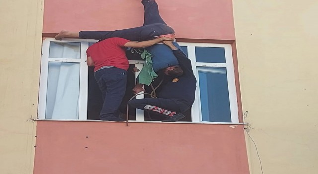 Evine çatıdan sarkıp pencereden girmek istedi, halat kısa gelince asılı kaldı