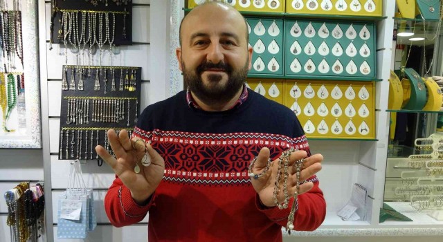 Saç tellerinden takı tasarımı yapıyor