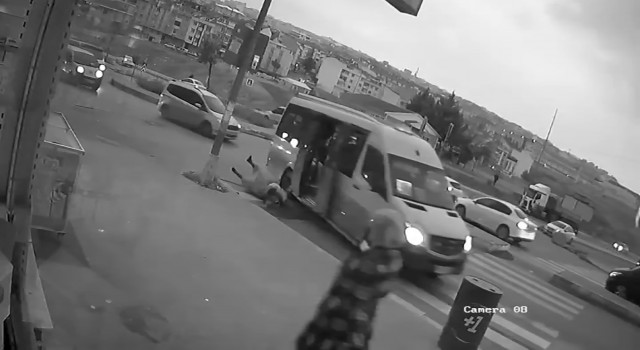 Kapısı açık minibüs ters yönden dönerken kucağında çocukla yola düşen kadın kamerada