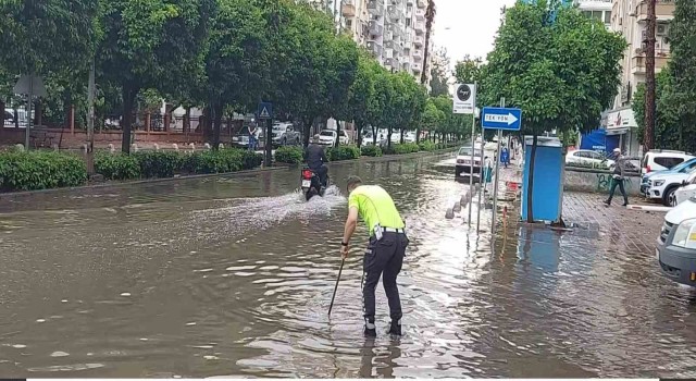 Polisten örnek davranış: Su dolu caddede tıkanan rögarı açtı