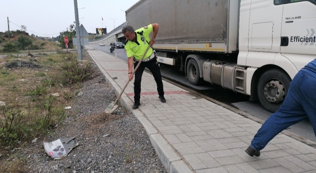 Tırdan yola saçılan yakıta trafik polisi kürekle kum atarak önlem aldı