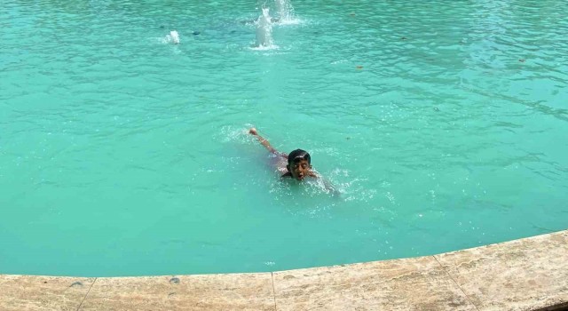 Kavurucu çöl sıcağında vatandaşlar gölgelik alanlara, çocuklar ise süs havuzuna koştu