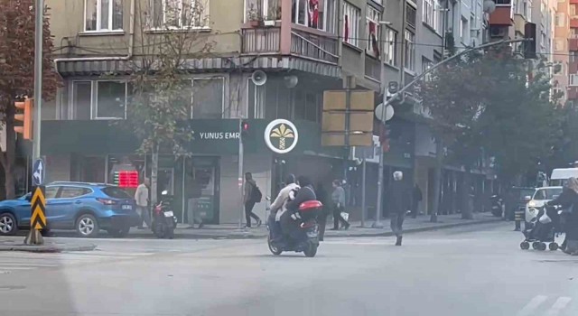Kasksız kucağında bebekle kırmızı ışığa rağmen elektrikli bisiklet ile yoluna devam ettiler