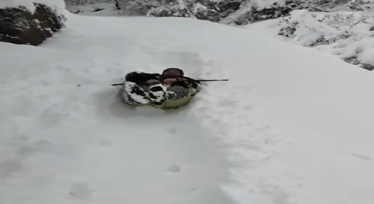 Yaşlı teyze eline aldığı çuvalla karda kaydı