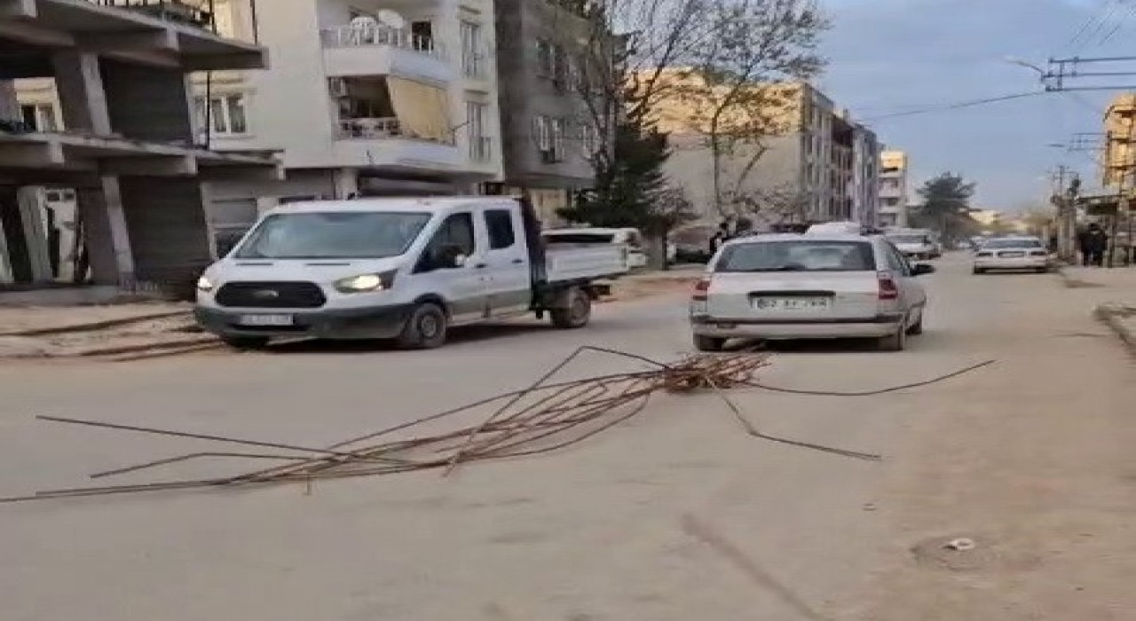 Otomobilin arkasına bağladığı demirlerle trafikte ilerledi