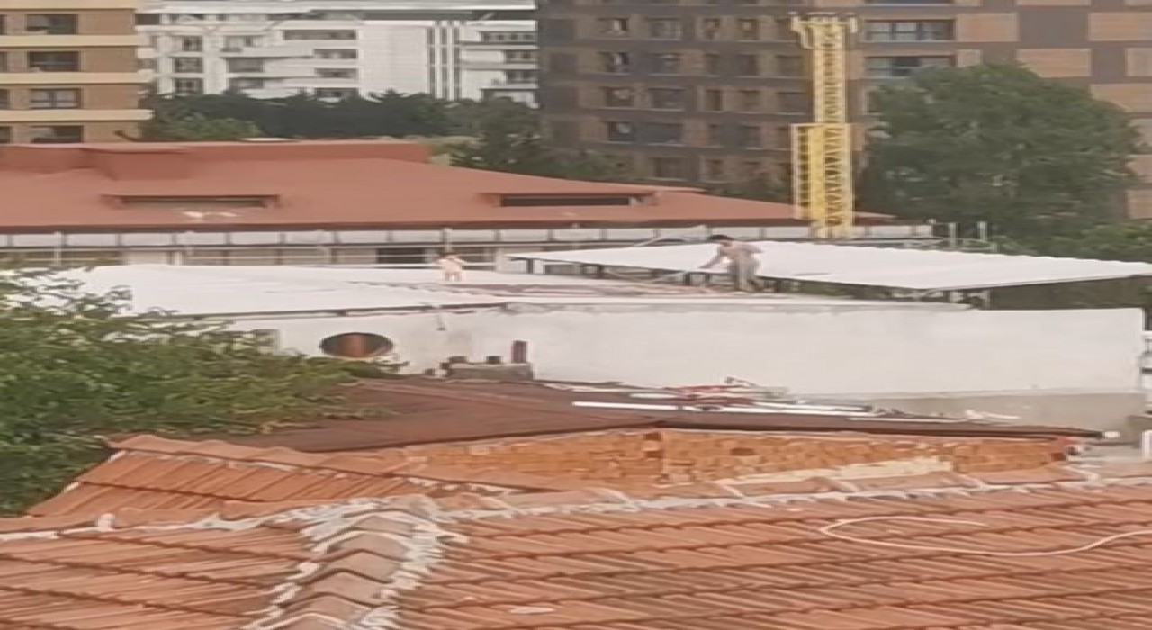 Çocukla birlikte çatıda halı yıkayan vatandaş kamerada