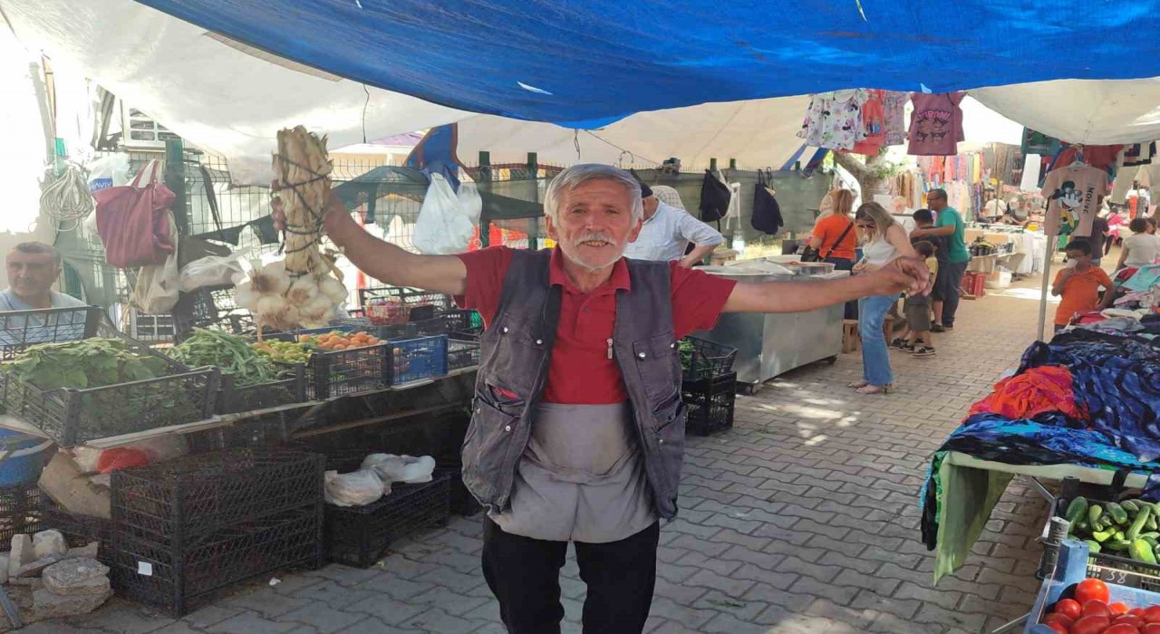 Şarkı söyleyerek ekmeğini kazanan pazarcı herkese neşe saçıyor