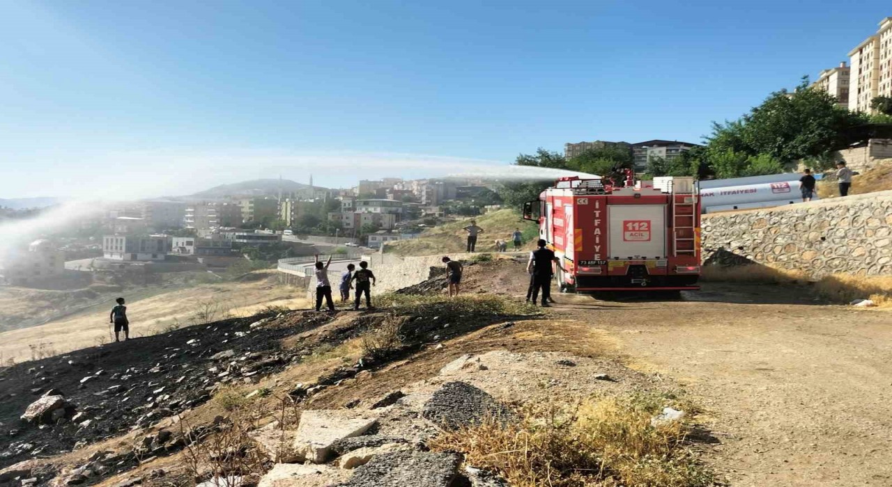İtfaiyeciler yangın söndürme derdinde, çocuklar serinlemenin keyfinde