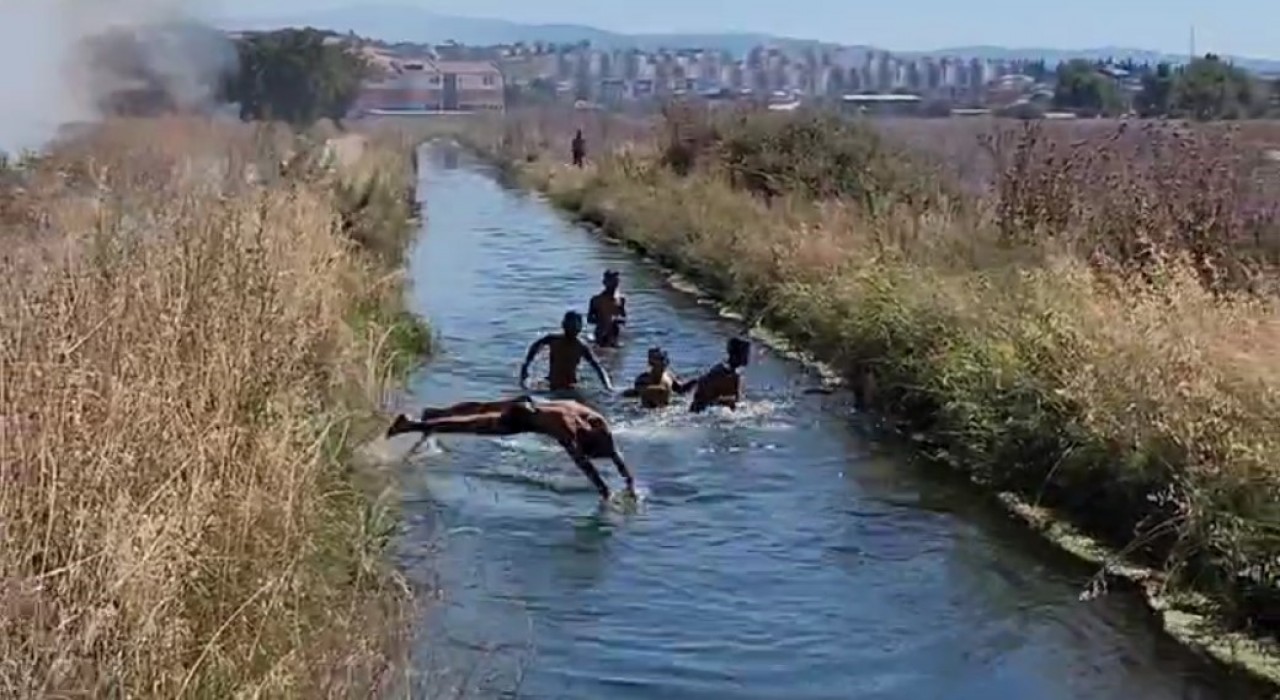 Çifte tehlike: Yangına rağmen su kanalındaki oyunlarını bozmadılar
