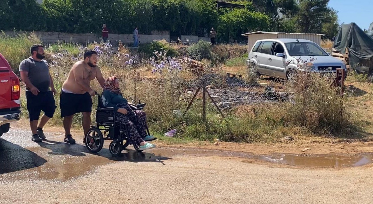 Evine yaklaşan alevlerden kurtarılan kadın tekerlekli sandalyeyle bölgeden uzaklaştırıldı