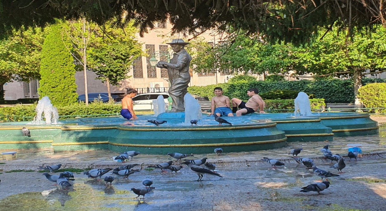 Sıcaklardan bunalan çocuklar süs havuzuna girerek serinlemeye çalıştı