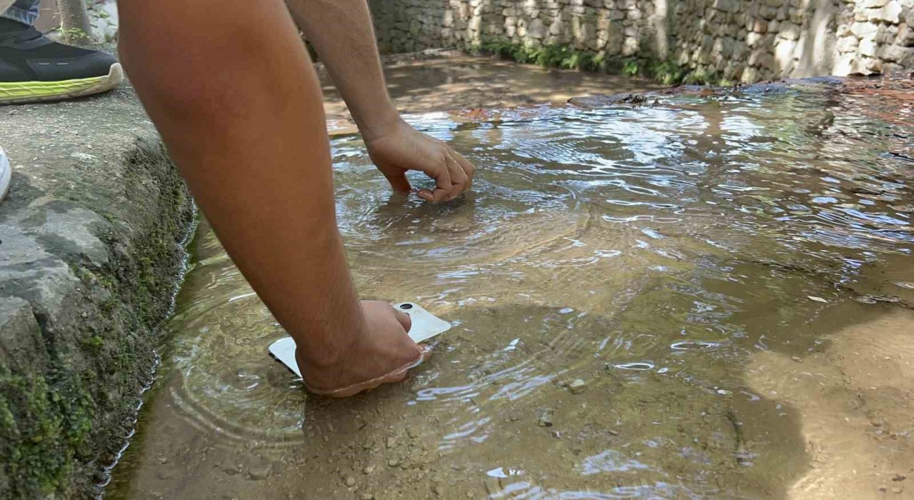 Sıcaklığın 45 dereceyi bulmasıyla telefonlarını suda soğuttular