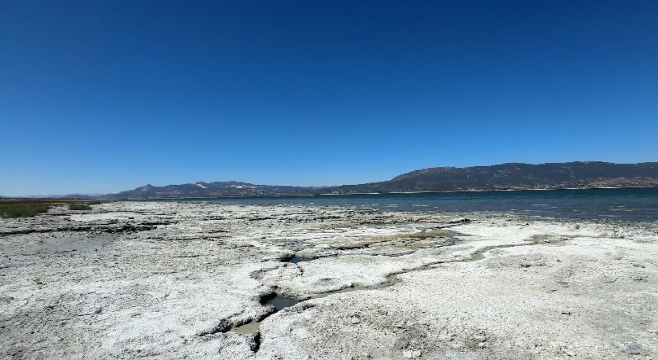 Burdur Gölünde balık tutmayı hayal ederken kuruyan gölde otlayan keçileri izliyor