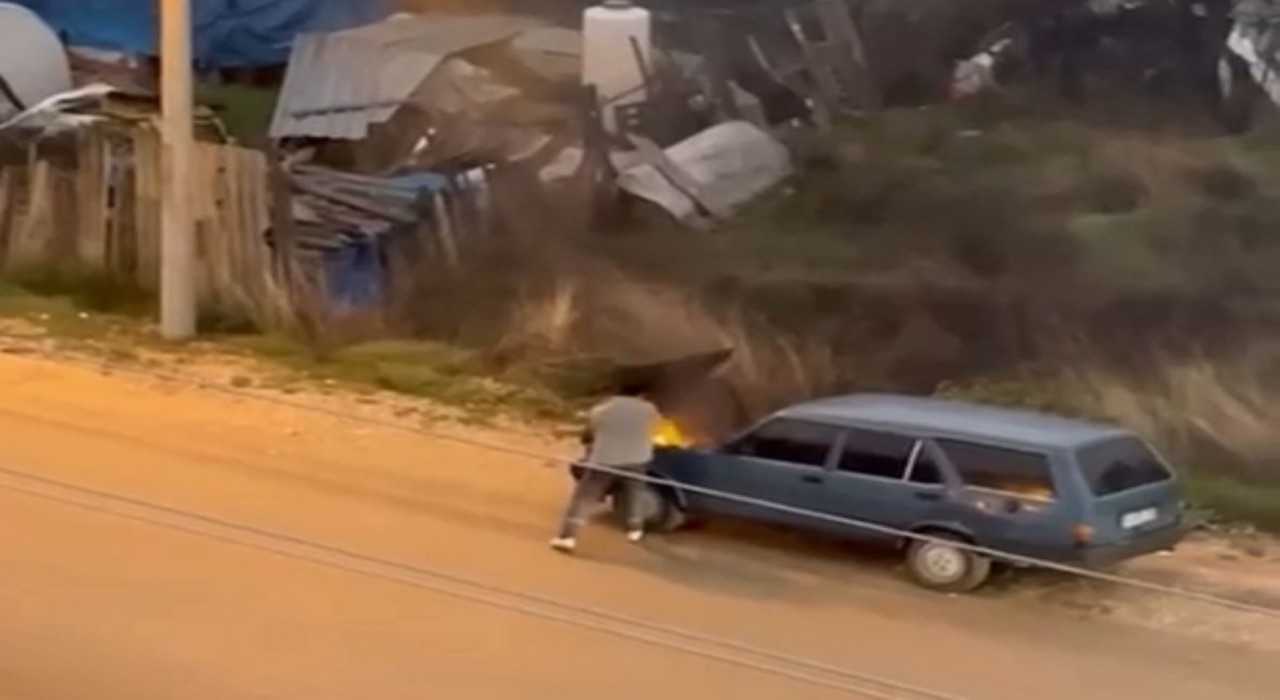 Alev alev yanan aracını kovayla su döküp söndürdü