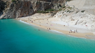Antalya’nın ünlü Kaputaş Plajı’na gelen turistler güzel havada denize girdi