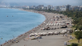Antalya’da tatilciler güneşli havanın keyfini denize girerek çıkardı