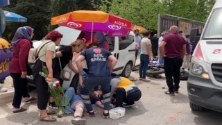 Kazada acı içinde yerde yatan kadına hemcinsinden plaj şemsiyeli koruma