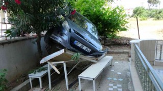 Antalyada otomobil apartmanın bahçesindeki masanın üzerine uçtu: 1 yaralı