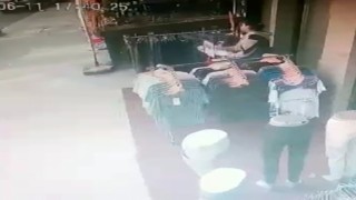 Mağazanın önündeki stanttan önce beğendi sonra çaldı: O anlar kamerada