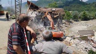 Sel afetinde büyük hasar gören evlerinin yıkılışını çaresizce izlediler