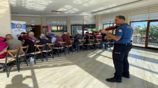Polis memurunun belinde silah, omzunda keman