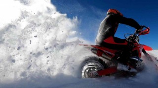 Karla kaplanan Ergan Dağının zirvesine motosikletleriyle çıkarak sezonun ilk kayağını yaptılar