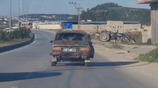 Kapısı açık halde seyreden eski otomobilin trafikte tehlikeli yolculuğu
