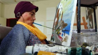 Engelli kadın ağzıyla depremzedeler için resim çiziyor