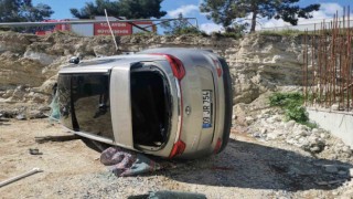 Yoldan çıkan lüks araç inşaat alanına devrildi