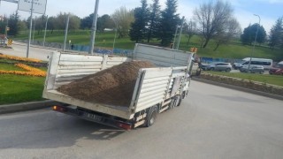 Kasa arka kapağı açık kamyon yükünü döke döke yoluna devam etti