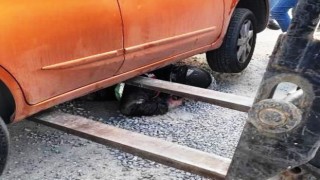 Mıcırda kayan motosiklet otomobilin altına girdi