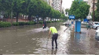 Polisten örnek davranış: Su dolu caddede tıkanan rögarı açtı