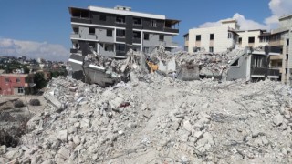 Ağır hasarlı binayı yıkan kepçe operatörü enkaz altında kaldı