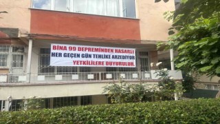 Bina çökmesin diye tahta parçalarıyla güçlendirme yapıp pankartla yardım istedi