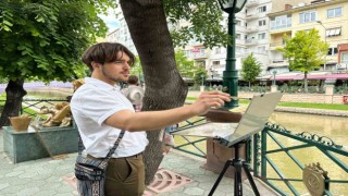 İlk kez geldiği şehrin sokaklarını gezerken sulu boya ile resmediyor