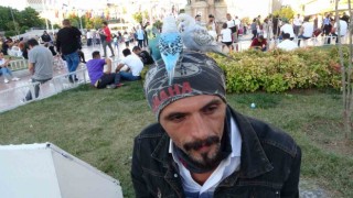 Başında gezdirdiği 3 muhabbet kuşuyla Taksimde ilgi odağı oldu
