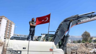 Deprem enkazında bulduğu Türk bayrağını iş makinesine astı