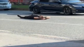 Bursada bir adam yüzlerce aracın geçtiği karayoluna boylu boyunca uzandı