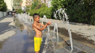 Cizrede sıcaklardan bunalan çocuklar su fıskiyesinin altında serinledi