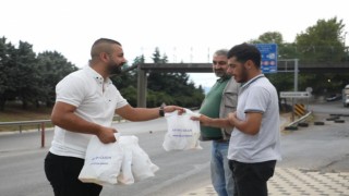 Servis bekleyen işçilere poğaça dağıtılıyor
