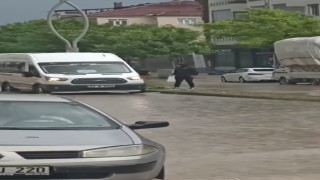 Dolmuş şoförü yağmur sularının ortasında kalan yolcuyu inip şoför kapısından içeri aldı