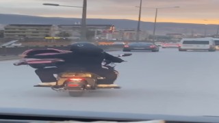 Motosiklet üzerinde bebeği pusetiyle taşıdı
