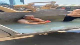 Sıcaktan bunalan işçiler, kepçeyi havuza çevirdi