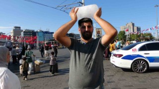 Taksimde sıcaktan bunalan simit satıcısı buz kalıbıyla serinledi