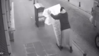 Kaldırıma vidalanmış tabelayı söken kadın görenleri hayrete düşürdü