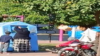 Giysi kumbarasına giren çocuk, topladığı kıyafetleri annesine verdi