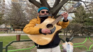 Aynı anda hem mızıka hem de gitar çalıyor